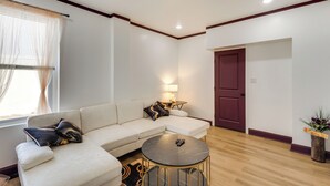 Una sala de estar moderna con un sofá modular, una mesa de centro redonda y una lámpara.