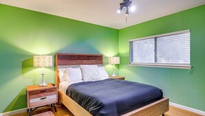 A bedroom with a bed, two bedside tables, two lamps, a ceiling fan, and a window with blinds. - Near Six Flags & Seaworld: San Antonio Family Home (San Antonio)