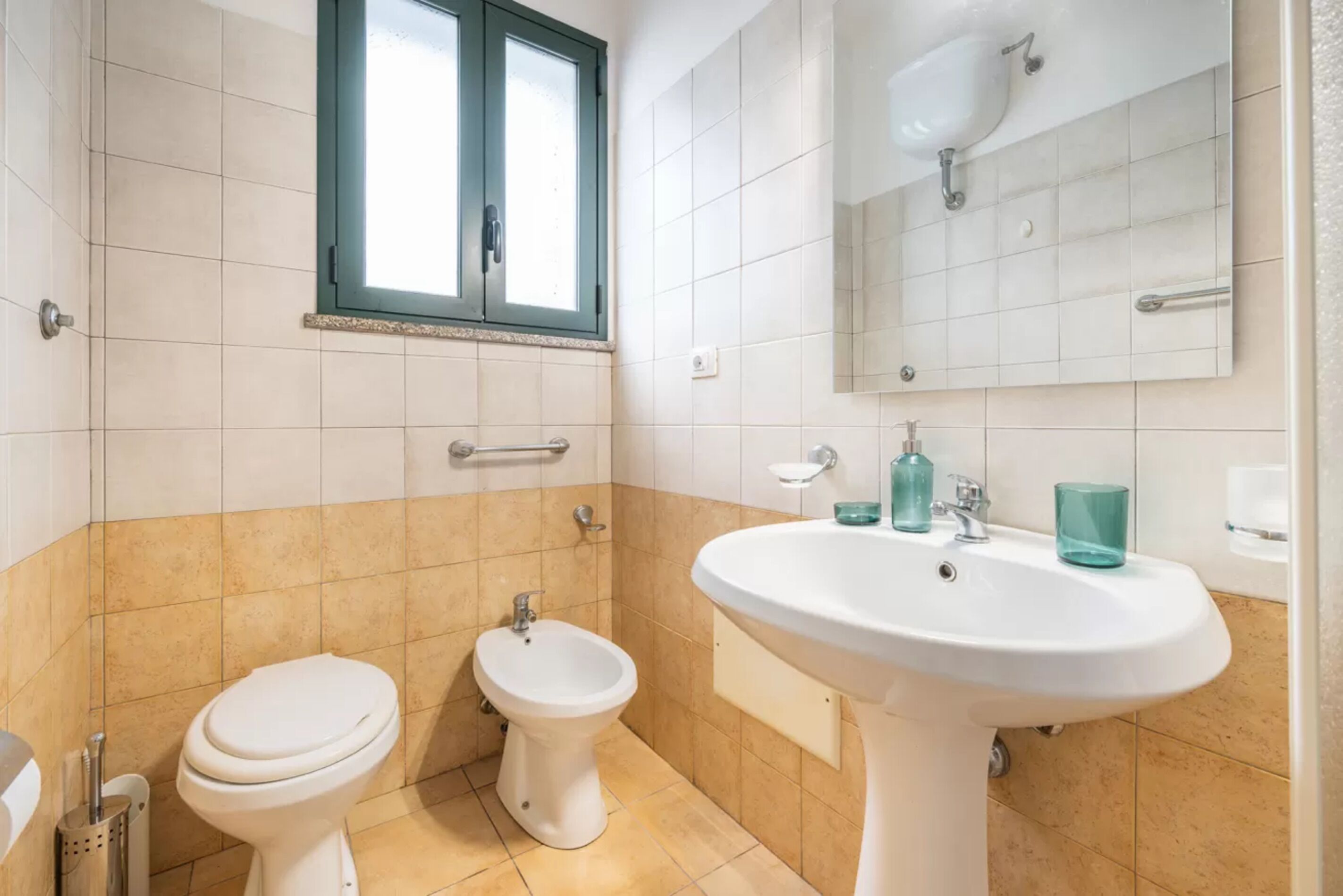 Une salle de bain équipée de toilettes, d’un bidet et d’un lavabo.