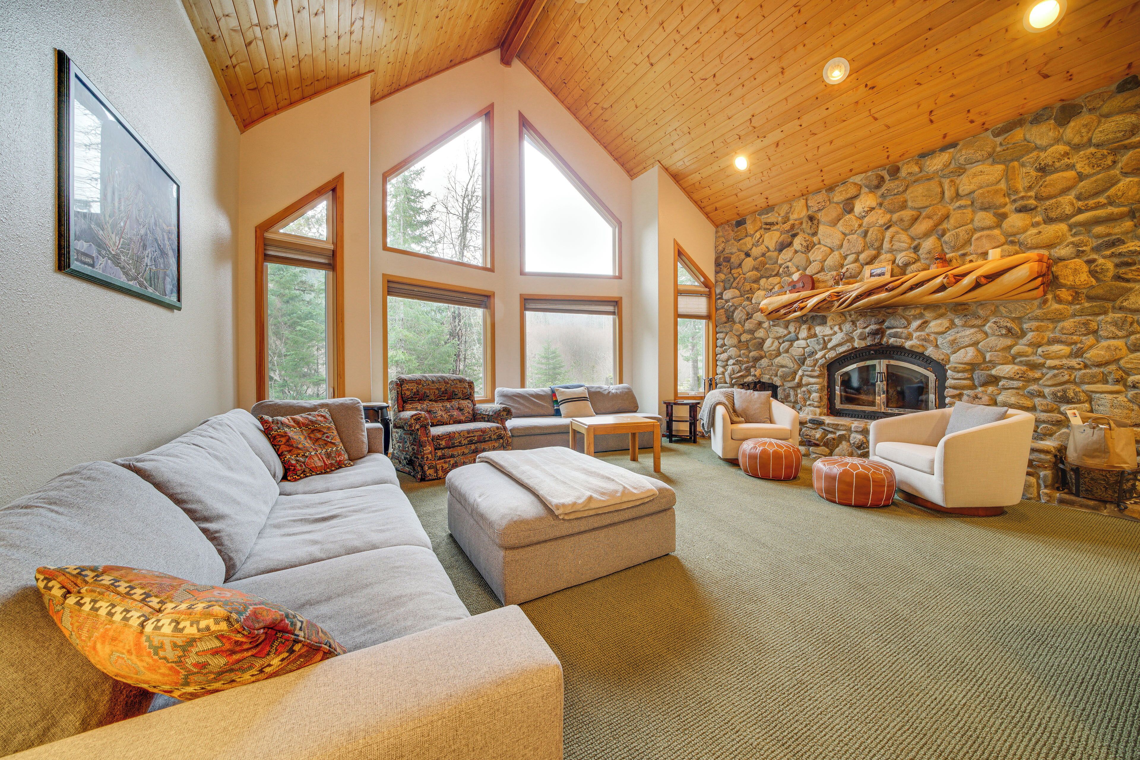 Una sala de estar acogedora con chimenea de piedra, ventanas amplias y asientos cómodos.