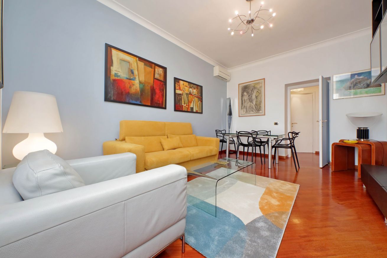 Un salon moderne comprenant un canapé, une table basse et un coin repas avec des chaises et une table.