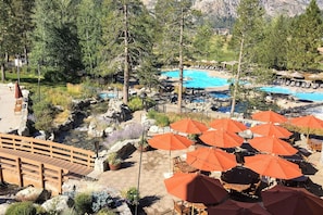 A resort with a swimming pool, outdoor seating, and a wooden bridge. - Everline Resort Studio w/ Luxury Resort Perks (Olympic Valley)