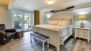 Un dormitorio con una cama grande, un banco, una mesita de noche y una silla.