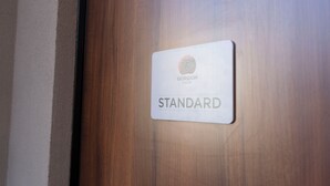 Een houten deur met een bord waarop staat 'GORGON HOUSE STANDARD'.