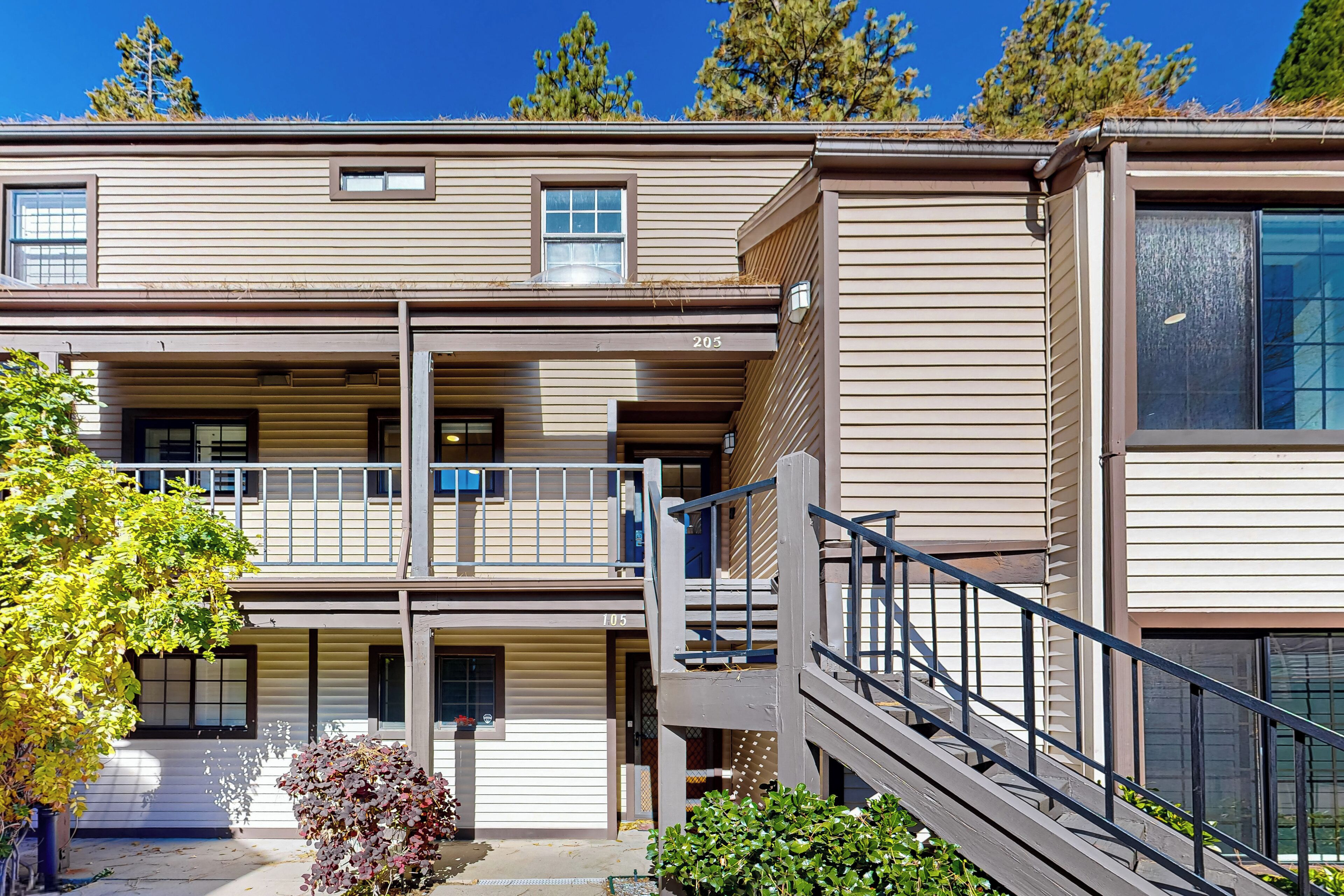 A multi-story building with a flat roof, a balcony on the second floor, and a staircase leading to the upper levels.