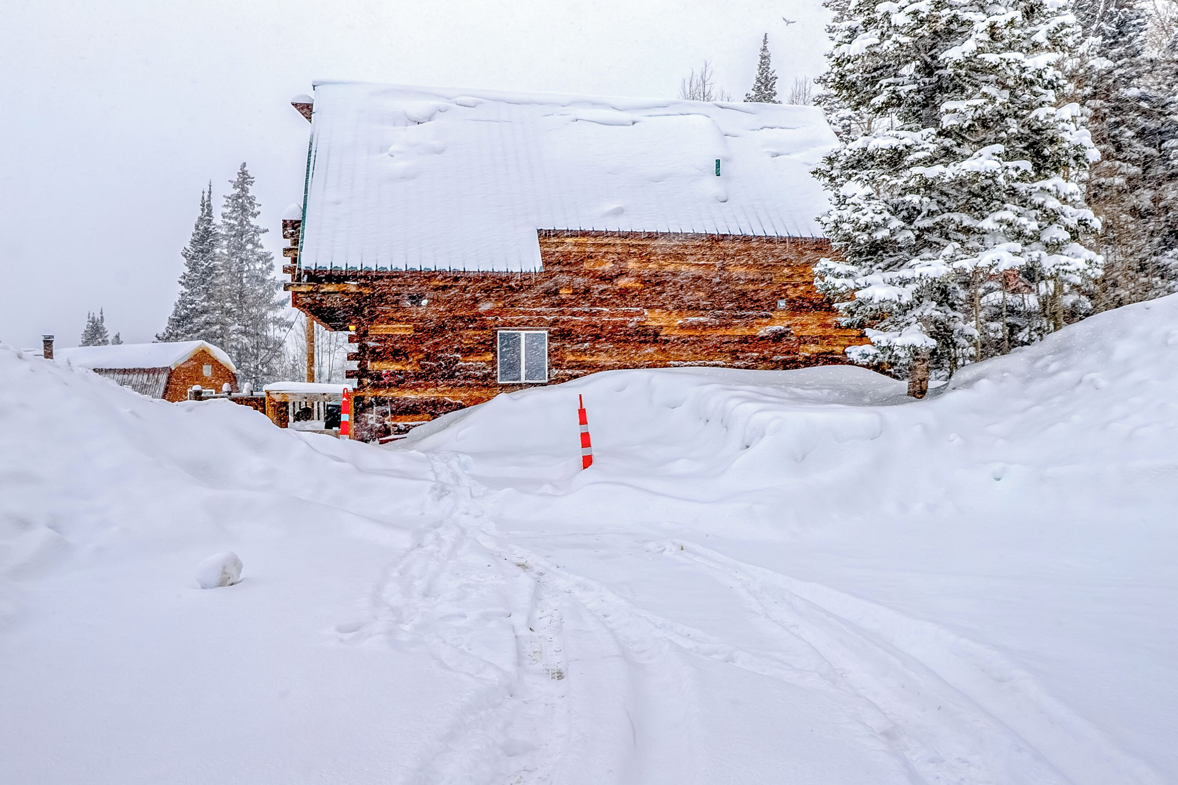 A snow-covered building with a wooden exterior and a snow-covered roof.