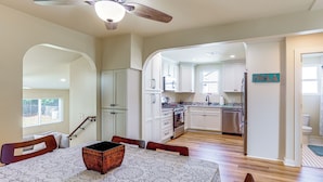 A spacious kitchen with white cabinets, a dining area with a table and chairs, and a ceiling fan. - 8 Mi to Dtwn New Orleans! Newly Renovated Home (Metairie)