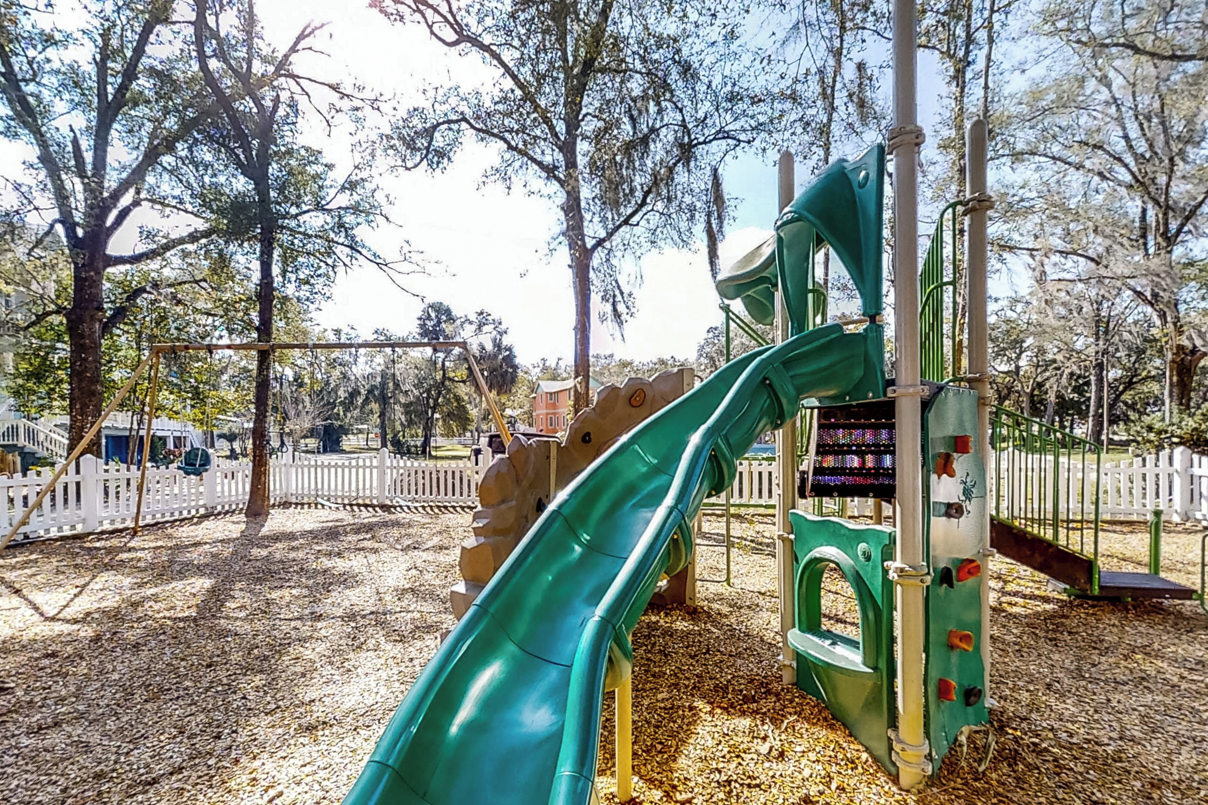 Ein Spielplatz mit einer grünen Rutsche und Klettergerüsten.