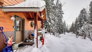 A wooden cabin with a snow-covered porch and a welcome sign. - Secluded Mtn Retreat w/ Resort Perks in Whitefish! (Whitefish)