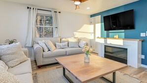 A living room with a sofa, coffee table, and fireplace. - Riverfront Reset! Dells Cabin w/ Kayaks & Deck (Wisconsin Dells)