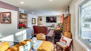 A cozy living room with a fireplace, a dining area with a wooden table, and a view of the outside. - Spacious & Family Friendly! Lincoln Home Near Dtwn (Lincoln)