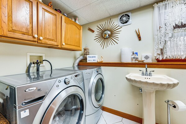 A laundry area with a front-loading washer and dryer, a sink, and a decorative mirror. - Spacious Yard w/ Gazebo: Charming Windsor Retreat (Windsor)