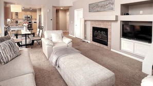 A spacious living room with a sofa, ottoman, and a fireplace. - Littleton Home w/ Deck - 24 Mi to Denver! (Littleton)