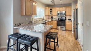A modern kitchen with wooden cabinets, granite countertops, and stainless steel appliances. - Littleton Home w/ Deck - 24 Mi to Denver! (Littleton)