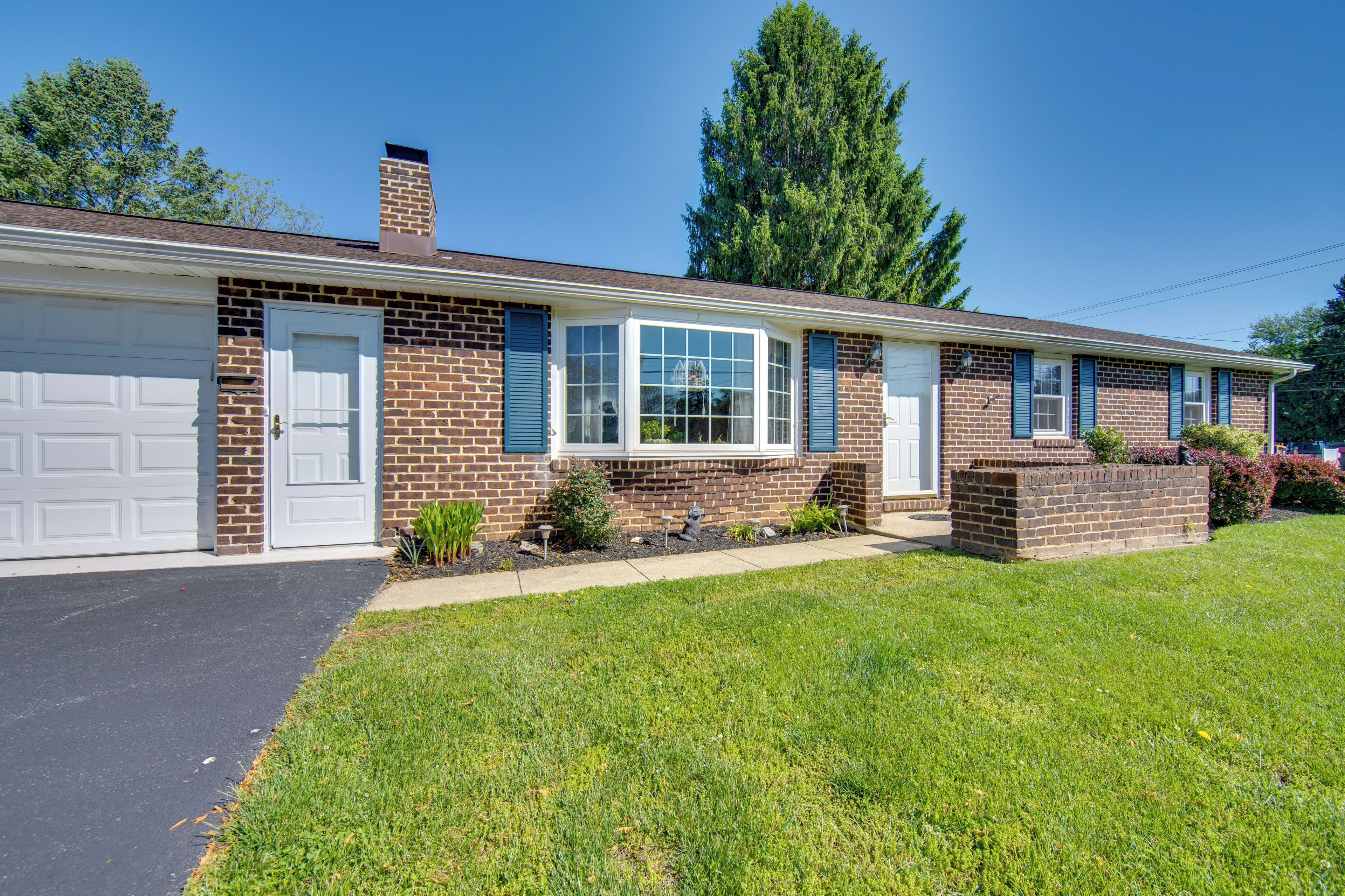 A two-story house with a garage, brick exterior, and a well-maintained lawn.