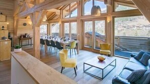 Un interior espacioso de madera con comedor, sofá y una mesa de centro.