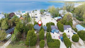Vue aérienne d’un quartier résidentiel avec des maisons, une plage et une étendue d’eau.