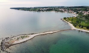 A coastal town with a clear view of the sea, a sandy beach, and residential buildings along the shore. - Apartment Near the Beach With Garden (Umag)