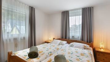 Une chambre d’hôtel avec un lit, deux lampes de chevet et une fenêtre avec des rideaux.