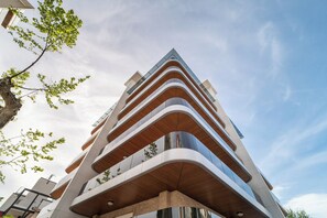 Un bâtiment moderne doté de nombreux balcons et surplombant un ciel dégagé.