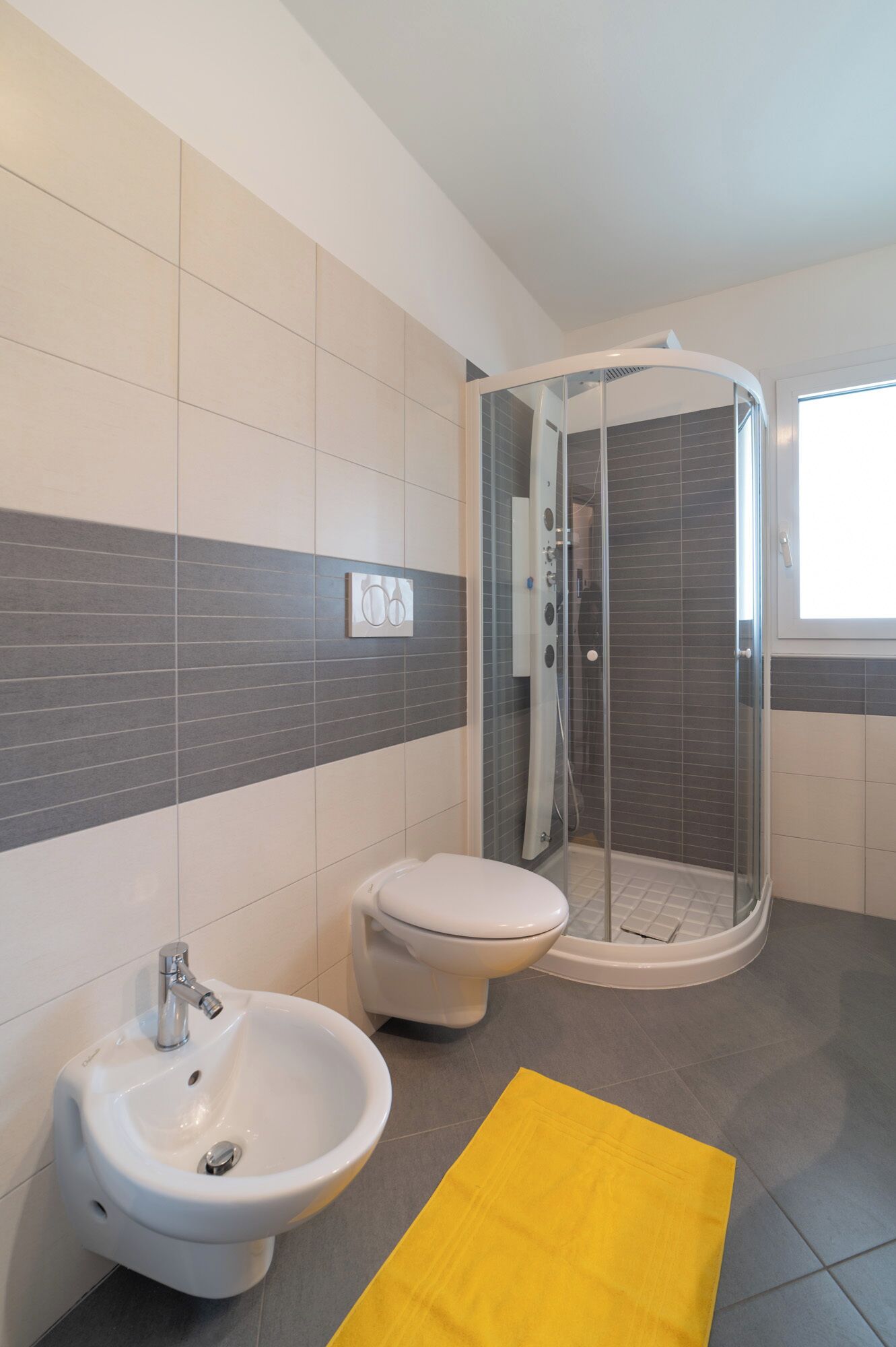 Un bagno moderno con cabina doccia, bidet e water.