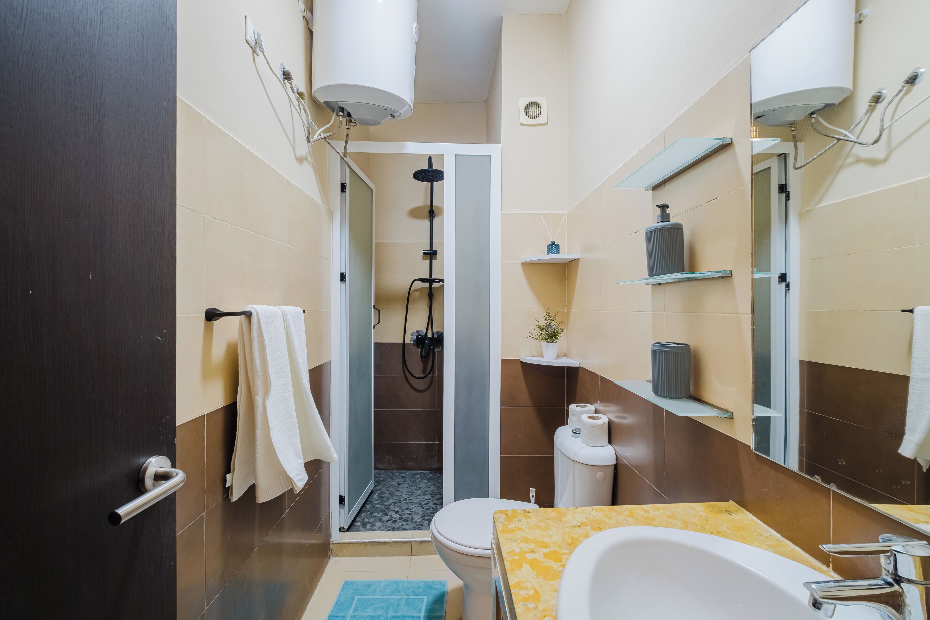 A modern bathroom with a shower, toilet, and sink.