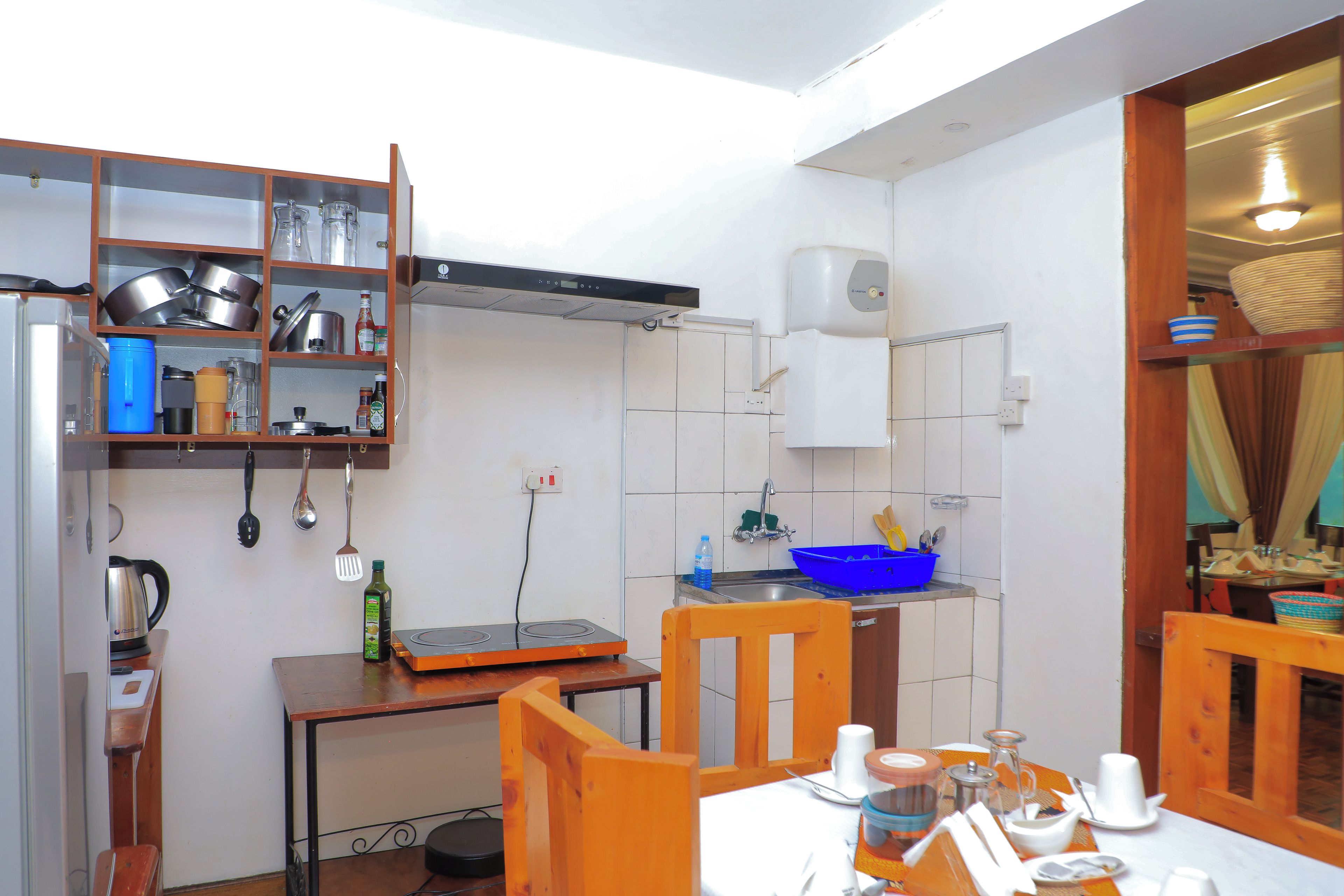 A compact kitchen with a stove, sink, and various utensils.