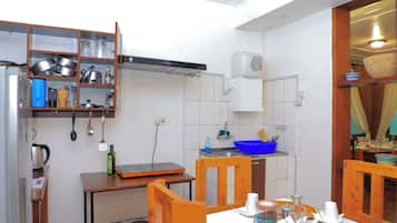A compact kitchen with a stove, sink, and various utensils.