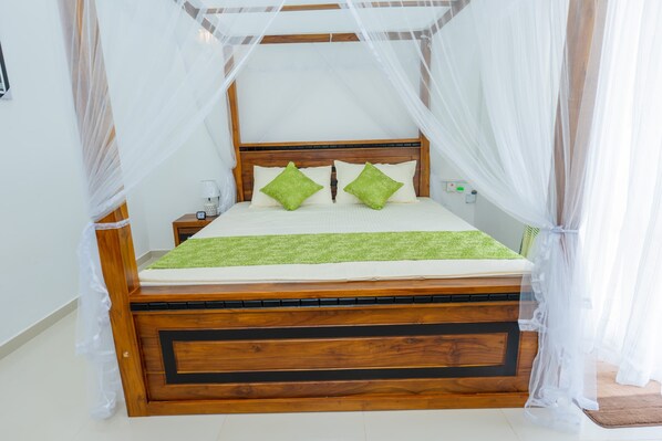 A bed with a wooden frame, green pillows, and a white bedspread.