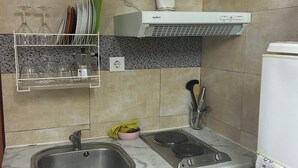 Una cocina con un lavamanos, estufa y escurreplatos.