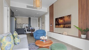 A modern living room with a sofa, armchairs, a coffee table, and a dining area in the background. - NOK Elegant 2BR Apt by Vistacana (Punta Cana)
