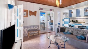 A living room with a sofa, a glass coffee table, a TV, and a wooden ceiling. - Holiday Home 'Shellls Apartment' with Shared Terrace, Wi-Fi and Air Conditioning (Carvoeiro)