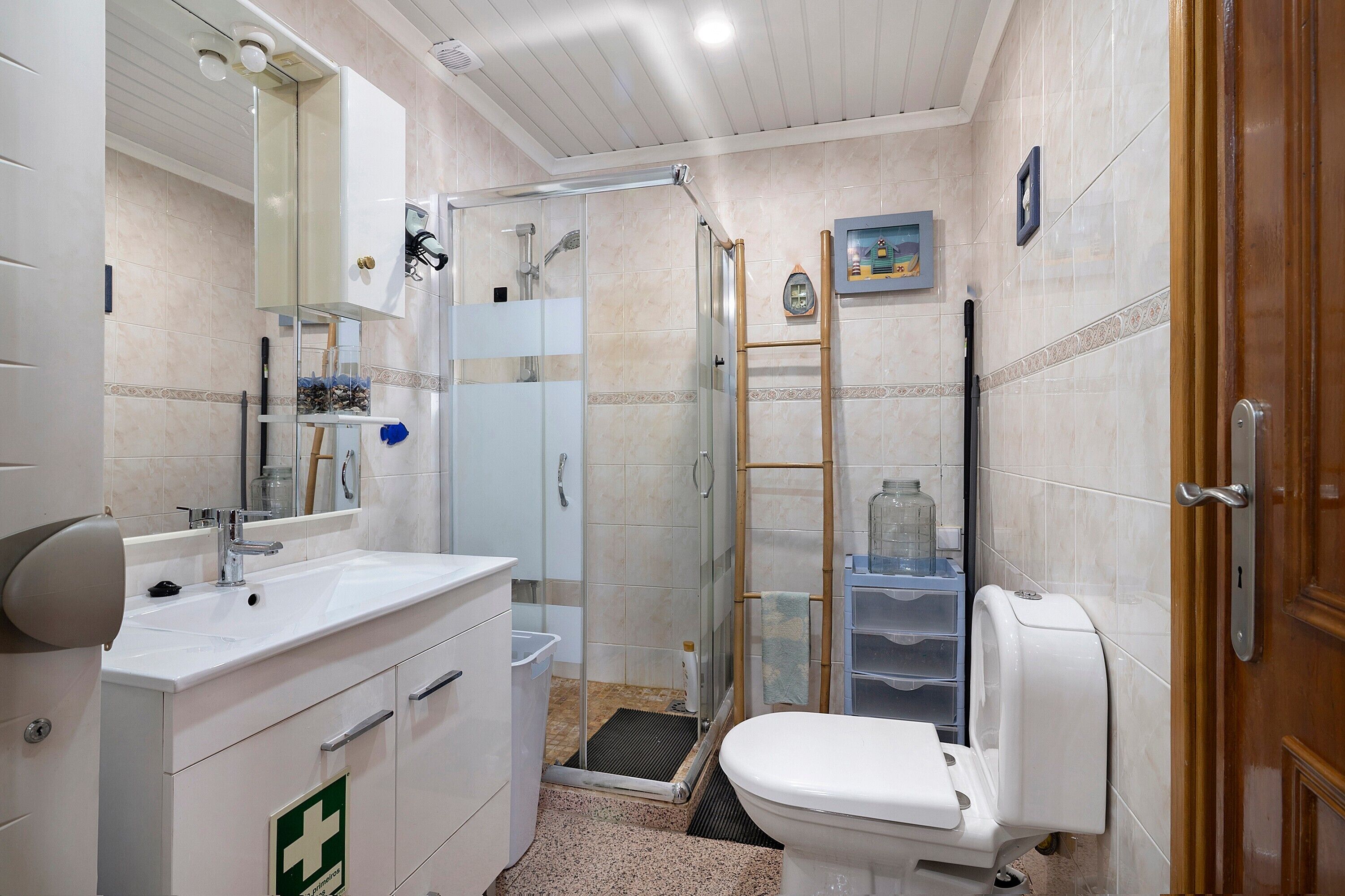 A bathroom with a sink, toilet, shower, and a glass door shower stall.