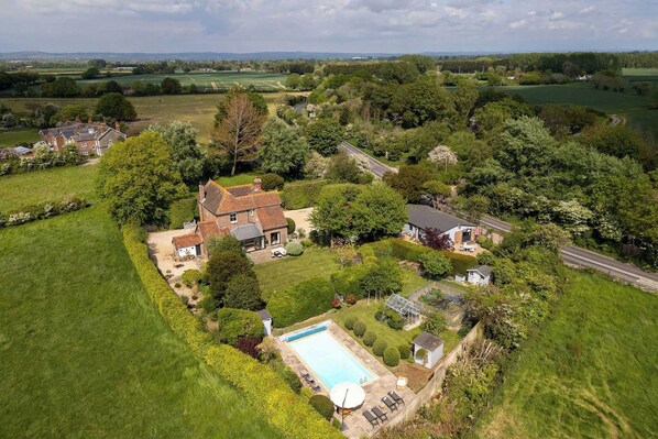 A large house with a swimming pool, surrounded by lush greenery and fields. - Victorian House, Sleeps 14, Pool and Gardens (Sidlesham)
