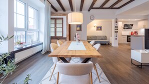Un comedor moderno con una mesa de madera, sillas blancas y una lámpara colgante.