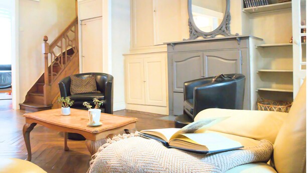 Ein Wohnzimmer mit Kamin, Treppe und Bücherregal.