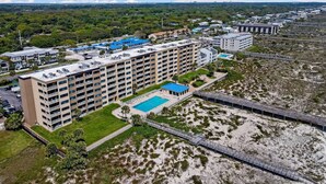 A large hotel with multiple floors, a swimming pool, and a beach area. - Cozy Ocean View Family Retreat - 3BR - Amelia by the Sea (Fernandina Beach)