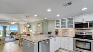 A modern kitchen with white cabinets, stainless steel appliances, and a large island. - Cozy Pet Friendly Condo by The Beach Omni Sea Dunes - 1616 (Fernandina Beach)