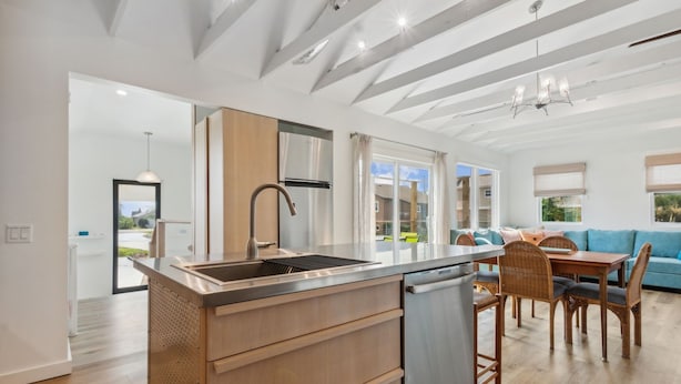 Una cocina moderna con una isla central, armarios de madera y lavavajillas integrado.