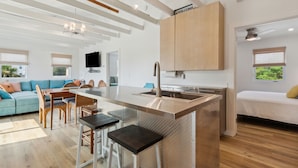 Una cocina moderna con una isla central, armarios de madera y una zona de comedor con sofá y sillas.
