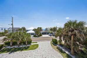 A residential street with houses, a paved driveway, and palm trees. - Private Pool and Hot Tub Fernandina Beach Retreat (Fernandina Beach)