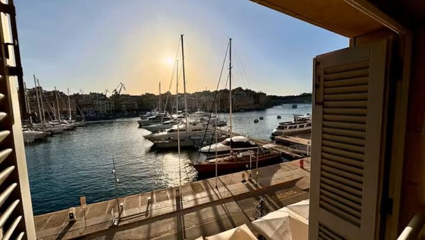 A marina with boats docked, a clear sky, and a view of the water. - Bormla Seafront 3 Bedroom Apartment (Birgu)