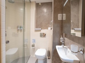 A modern bathroom with a glass-enclosed shower, a white toilet, and a sink with a mirror. - Bormla Seafront 3 Bedroom Apartment (Birgu)