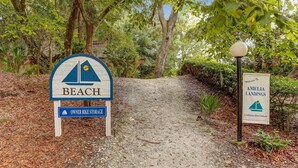 A sign for 'Beach' with a 'Owner Bike Storage' sign below it, and a welcome sign for 'Amelia Landings Condominium Resort Community'. - Fernandina Beach Hidden Gem Amelia Landings - 9F (Fernandina Beach)
