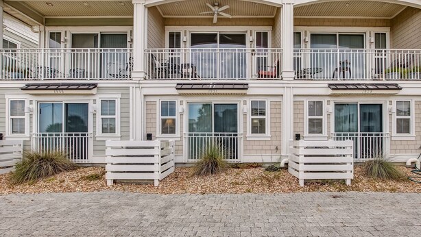A two-story building with balconies, large windows, and a brick pathway. - Haven across the Ocean - Pet Friendly 1931 S Fletcher (Fernandina Beach)
