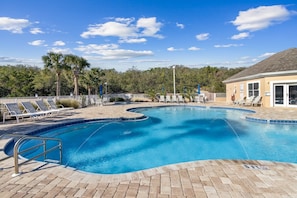A swimming pool with lounge chairs and a building in the background. - Spacious 3BR Condo by The Beach Ocean Park - 106 (Fernandina Beach)