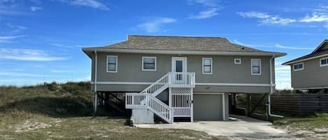 A two-story house with a front porch and a staircase leading to the second floor.