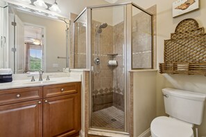 A bathroom with a glass-enclosed shower, a white toilet, and a vanity with a mirror and two sinks. - Seven Seas Townhome - Pet Friendly - Fernandina Beach (Fernandina Beach)