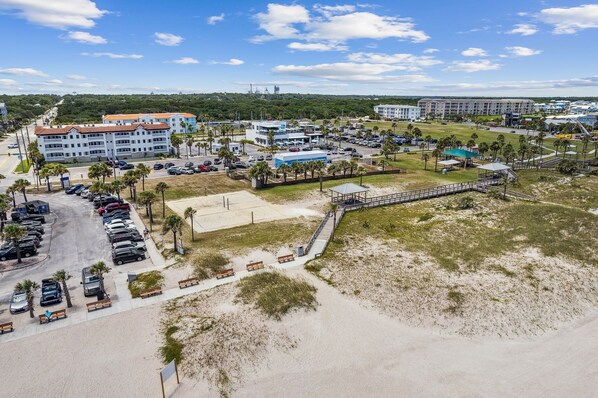 An aerial view of a coastal area with a parking lot, beach, and buildings. - Luxury Private Beachfront Condo w/ Parking Garage & Stunning Views (Fernandina Beach)