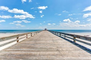 A wooden pier extending towards the beach with a railing on both sides. - Beachfront Family Condo w/ Pool, Fishing, and Pier Access Amelia by the Sea (Fernandina Beach)